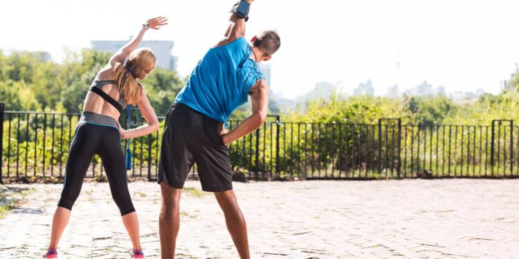 Casal alongando - Créditos: depositphotos.com / ArturVerkhovetskiy