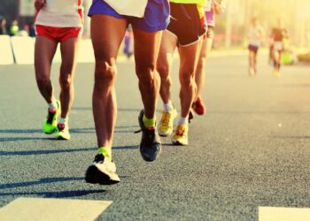 Pessoas correndo na rua em evento de corrida e caminhada - Créditos: depositphotos.com / lzf