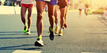 Pessoas correndo na rua em evento de corrida e caminhada - Créditos: depositphotos.com / lzf