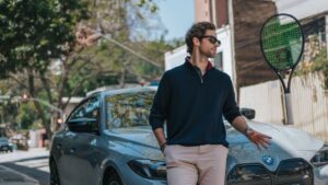 Gabriel Sidney encostado em uma BMW