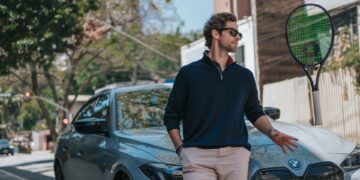 Gabriel Sidney encostado em uma BMW