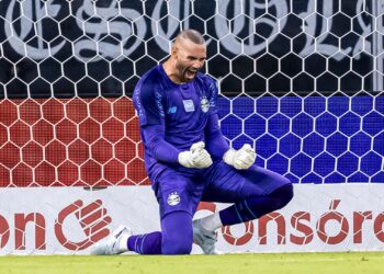 **Título:** Weverton surpreende, desbanca concorrentes e celebra vaga na Copa do Mundo **Linha fina:** Goleiro do Grêmio revelou emoção após convocação de Carlo Ancelotti para disputar o segundo Mundial da carreira. **Palavra-chave principal:** Weverton **Meta descrição:** Weverton comenta convocação para a Copa do Mundo, fala sobre concorrência e revela bastidores da vaga com Ancelotti. --- **Texto completo:** **Weverton foi uma das maiores surpresas da convocação de Carlo Ancelotti para a Copa do Mundo de 2026 e admitiu que viu o cenário mudar nos últimos dias antes da lista final.** Aos 38 anos, o goleiro do Grêmio garantiu presença no segundo Mundial da carreira e afirmou que uma sequência de grandes atuações ajudou a colocar seu nome entre os escolhidos da Seleção Brasileira. Convocado pela primeira vez por Ancelotti, o experiente arqueiro superou nomes como Bento, Hugo Souza e John para fechar a lista ao lado de Alisson e Ederson. Durante entrevista coletiva concedida nesta terça-feira, na Arena do Grêmio, Weverton comentou o sentimento após garantir vaga na Copa. *“É verdade que nos últimos dias parece que as coisas foram se alinhando ao meu favor. Foram grandes partidas, grandes jogos, grandes defesas, enfim, que me ajudaram a chegar a esse momento”*, declarou. ## Weverton aposta na experiência para ajudar a Seleção Weverton destacou que a experiência acumulada na Seleção Brasileira teve peso importante na escolha feita pela comissão técnica. O goleiro soma mais de 55 convocações pela Amarelinha, além do título olímpico conquistado em 2016, quando foi decisivo na final contra a Alemanha. *“Acho que o meu histórico na Seleção, o meu caráter e o meu profissionalismo pesaram. Mesmo sem me conhecer pessoalmente, o Ancelotti confiou em mim”*, afirmou. O jogador também destacou que pretende honrar a oportunidade recebida pelo treinador italiano durante o Mundial. ## Weverton relembra trauma da última Copa Reserva no Catar, em 2022, Weverton afirmou que a experiência da eliminação ainda o acompanha e garantiu que fará tudo para ajudar o Brasil na busca pelo hexacampeonato. Segundo o goleiro, mesmo quem não entrar em campo terá papel importante dentro do grupo durante a competição. *“Existem várias maneiras de ser útil. Às vezes nem todo mundo vai jogar, mas todo mundo é importante”*, disse. Weverton ainda ressaltou que a dor da eliminação no último Mundial serve como motivação extra para a equipe em 2026. *“Quando fomos eliminados, vivi um clima que nunca mais quero viver na minha vida. Vou fazer o que for preciso para alcançar o sucesso”*, completou. Antes de se apresentar à Seleção Brasileira, o goleiro ainda defenderá o Grêmio nas partidas contra Palestino, Santos e Montevideo City Torque. O Brasil estreia na Copa do Mundo após amistosos diante de Panamá e Egito. **Legenda sugerida da imagem:** Weverton comemorou convocação para a segunda Copa do Mundo da carreira. **Alt text sugerido:** Weverton durante treino da Seleção Brasileira após convocação para a Copa do Mundo de 2026