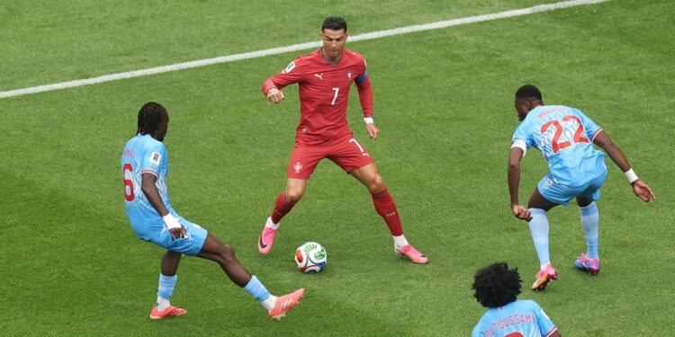 Crisitano Ronaldo cercado de jogadores da RD Congo